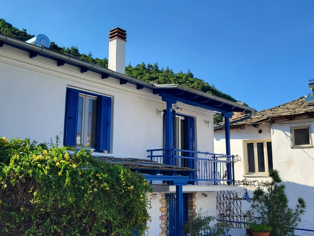 Λευκό σπίτι με μπλε παντζούρια